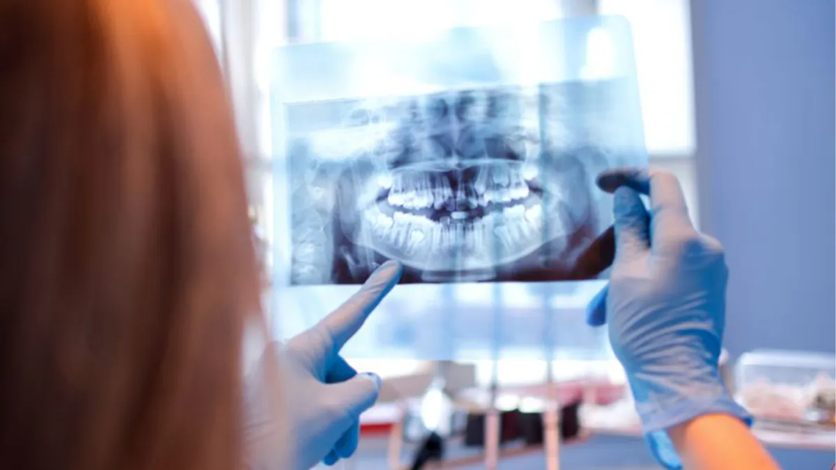 Profissional analisando radiografia panorâmica em tela